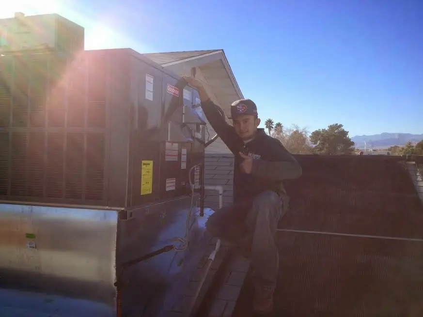 HVAC technician performing AC Tune-Up on a rooftop unit in Rahway